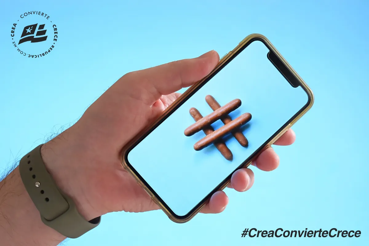 Mano sosteniendo un smartphone que muestra un hashtag